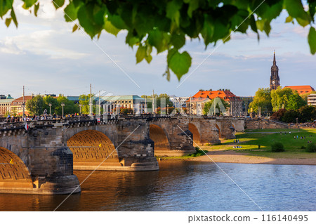Scenic cityscape Dresden old center view Bruhl terrace balcony  Augustus Elbe river bridge against sunset blue cloud sky. People walking central square at Holy Trinity church at Saxony Germany 116140495