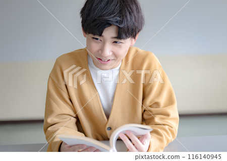 A young man reading a book A young man reading a book 116140945