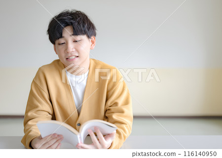 A young man reading a book A young man reading a book 116140950