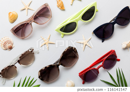 sunglasses with seashell lying on table background. Sunglasses on summer background. Top view flat lay with copy space for text sunglasses with seashell lying on table background. Sunglasses on summer background. Top view flat lay with copy space for text 116141547
