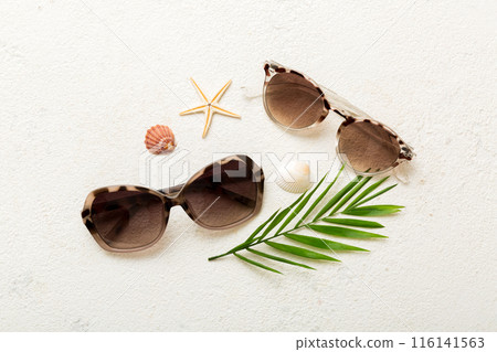 sunglasses with seashell lying on table background. Sunglasses on summer background. Top view flat lay with copy space for text sunglasses with seashell lying on table background. Sunglasses on summer background. Top view flat lay with copy space for text 116141563