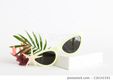 sunglasses with seashell lying on table background. Sunglasses on summer background. Top view flat lay with copy space for text 116141591