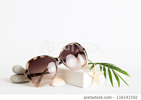 sunglasses with seashell lying on table background. Sunglasses on summer background. Top view flat lay with copy space for text 116141592