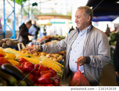 Middle aged man buying vegetables Middle aged man buying vegetables 116141639