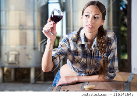 Woman is tasting wine at Italian wine factory Woman is tasting wine at Italian wine factory 116141642