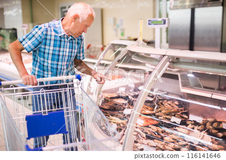 Mature senor choosing dried fish in supermarket 116141646