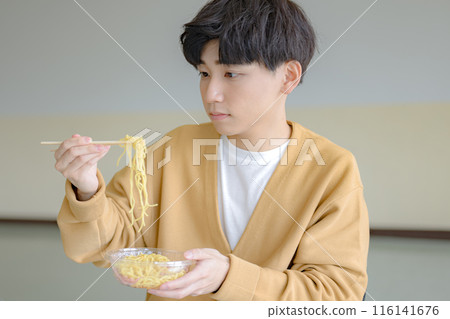 Young man lifting noodles Young man lifting noodles 116141676