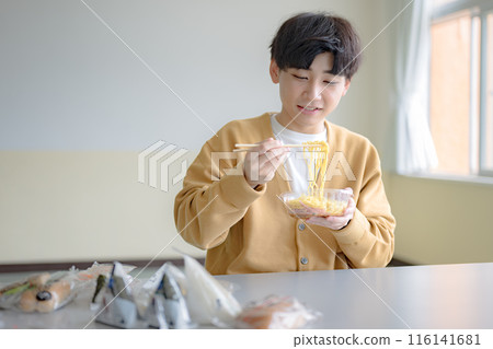 Young man lifting noodles Young man lifting noodles 116141681