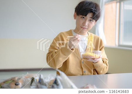 Young man lifting noodles Young man lifting noodles 116141683