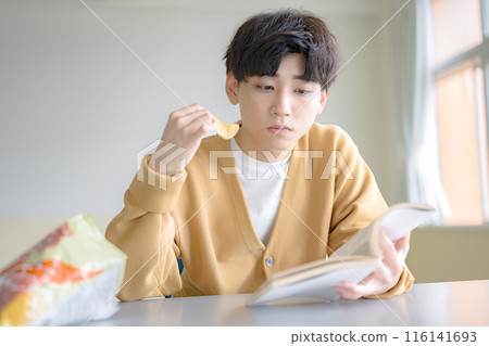 Boy eating potato chips 116141693
