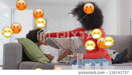 Biracial mother checking on her son lying on couch, both looking tired 116141737