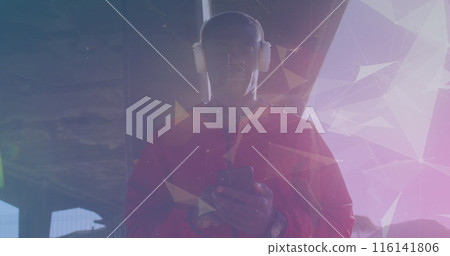 African American male athlete wearing headphones, holding smartphone 116141806