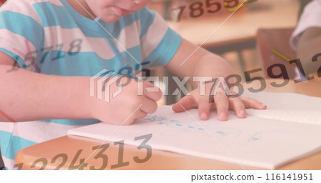 Caucasian boy drawing in school, African American girl watching 116141951