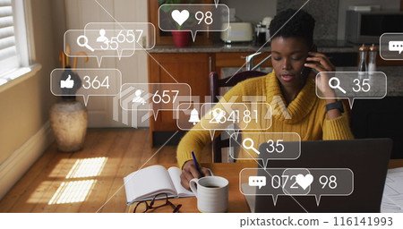 African American woman wearing yellow sweater is writing notes 116141993