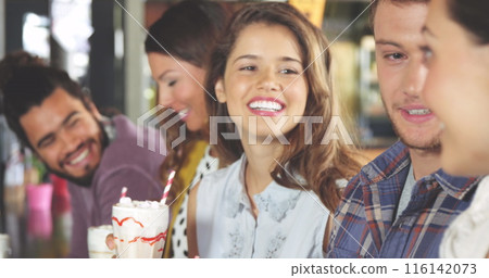Group of diverse friends enjoying time together, holding drinks 116142073