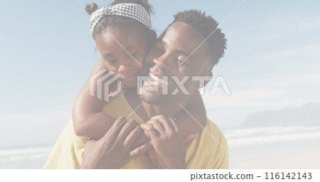 African American father holding young daughter, both smiling at beach African American father holding young daughter, both smiling at beach 116142143