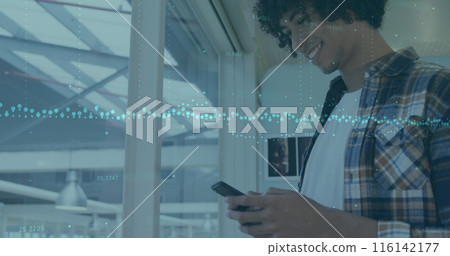 A young biracial chef with curly black hair and beard is looking at a smartphone A young biracial chef with curly black hair and beard is looking at a smartphone 116142177