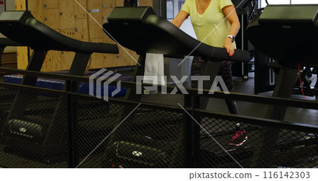 Caucasian senior coach training on treadmill in a gym 116142303