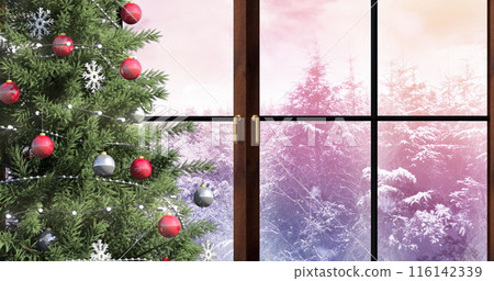 Christmas tree decorated with red and silver baubles stands inside 116142339