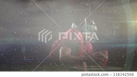 African American male athlete wearing football gear kneeling on field African American male athlete wearing football gear kneeling on field 116142508