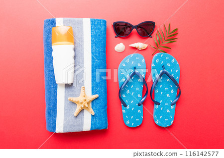 Summer holiday concept. Top view of beach towel, flip flop and sunscreen cream on table Top view with copy space for text 116142577