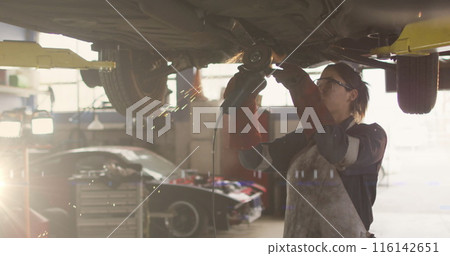 Image of light trails over biracial female mechanic reapiring car 116142651