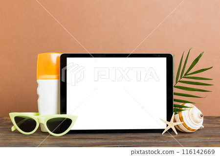Flat lay composition with tablet and beach accessories on colored background. Tablet computer with blank screen mock up with copy space Flat lay composition with tablet and beach accessories on colored background. Tablet computer with blank screen mock up with copy space 116142669