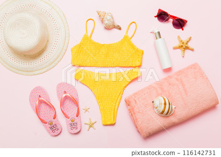 Woman swimwear and beach accessories flat lay top view. Top view with bikini outfit on color background. Vacation concept copy space Woman swimwear and beach accessories flat lay top view. Top view with bikini outfit on color background. Vacation concept copy space 116142731