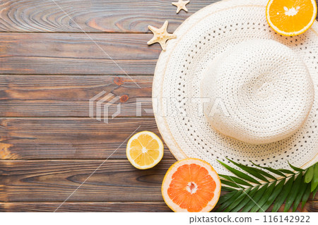 Top view of various seashells placed near colorful fruit and stylish summer accessories on table background. Summer concept. Flat lay. Top view with copy space for text 116142922