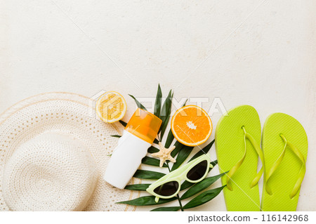 Top view of various seashells placed near colorful fruit and stylish summer accessories on table background. Summer concept. Flat lay. Top view with copy space for text 116142968