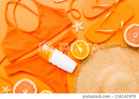 Swimming pool accessories concept. Top view of beach items on table, bright bikini, straw hat, and sunscreen skincare cream. Colorful beach wear. top view Flat lay, copy space Swimming pool accessories concept. Top view of beach items on table, bright bikini, straw hat, and sunscreen skincare cream. Colorful beach wear. top view Flat lay, copy space 116142979
