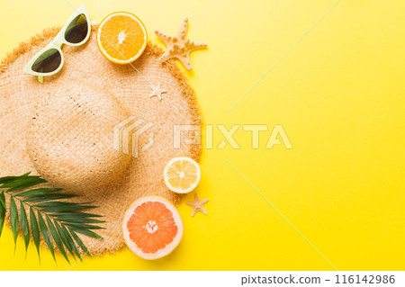 Top view of various seashells placed near colorful fruit and stylish summer accessories on table background. Summer concept. Flat lay. Top view with copy space for text 116142986