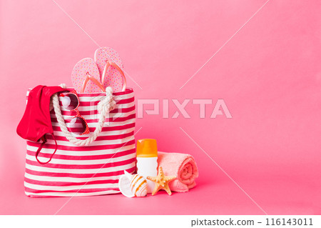 Stylish bag with beach accessories . Summer holiday concept. Top view of beach bag with sunscreen cream with space for text 116143011