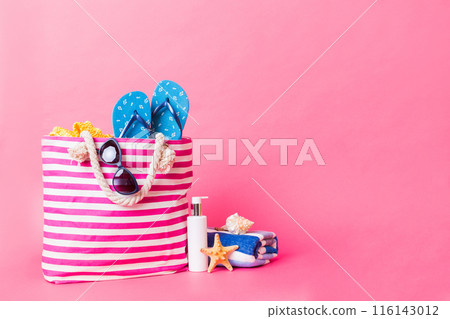 Stylish bag with beach accessories . Summer holiday concept. Top view of beach bag with sunscreen cream with space for text 116143012