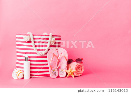 Stylish bag with beach accessories . Summer holiday concept. Top view of beach bag with sunscreen cream with space for text 116143013