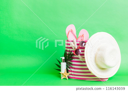 Stylish bag with beach accessories . Summer holiday concept. Top view of beach bag with sunscreen cream with space for text 116143039