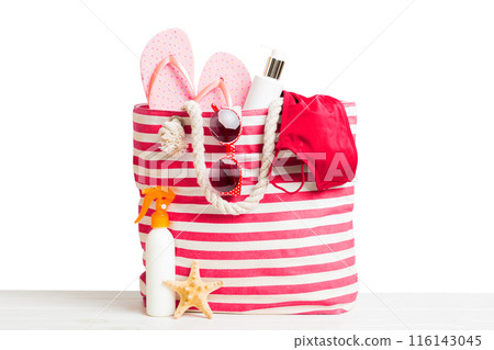 Stylish bag with beach accessories . Summer holiday concept. Top view of beach bag with sunscreen cream with space for text Stylish bag with beach accessories . Summer holiday concept. Top view of beach bag with sunscreen cream with space for text 116143045