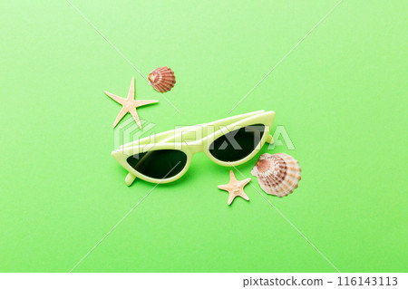 sunglasses with seashell lying on table background. Sunglasses on summer background. Top view flat lay with copy space for text 116143113
