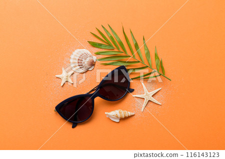 sunglasses with seashell lying on table background. Sunglasses on summer background. Top view flat lay with copy space for text 116143123