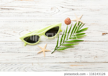 sunglasses with seashell lying on table background. Sunglasses on summer background. Top view flat lay with copy space for text 116143126