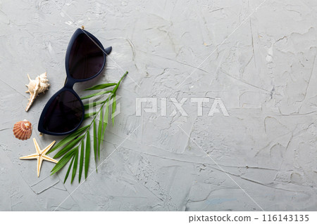 sunglasses with seashell lying on table background. Sunglasses on summer background. Top view flat lay with copy space for text sunglasses with seashell lying on table background. Sunglasses on summer background. Top view flat lay with copy space for text 116143135