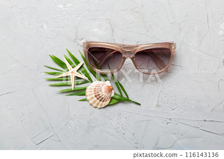 sunglasses with seashell lying on table background. Sunglasses on summer background. Top view flat lay with copy space for text sunglasses with seashell lying on table background. Sunglasses on summer background. Top view flat lay with copy space for text 116143136