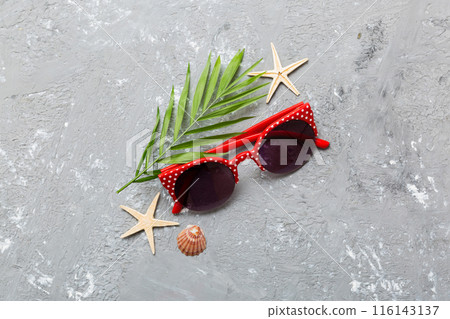 sunglasses with seashell lying on table background. Sunglasses on summer background. Top view flat lay with copy space for text 116143137