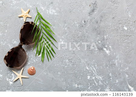 sunglasses with seashell lying on table background. Sunglasses on summer background. Top view flat lay with copy space for text 116143139