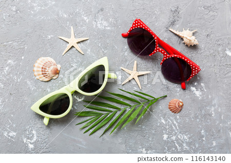 sunglasses with seashell lying on table background. Sunglasses on summer background. Top view flat lay with copy space for text 116143140