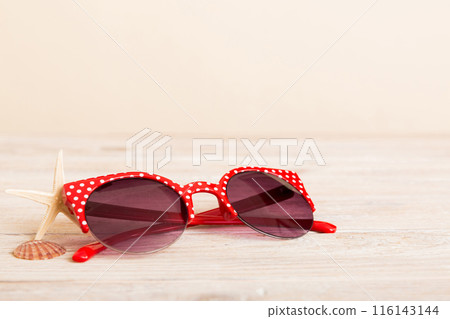 sunglasses with seashell lying on table background. Sunglasses on summer background. Top view flat lay with copy space for text sunglasses with seashell lying on table background. Sunglasses on summer background. Top view flat lay with copy space for text 116143144