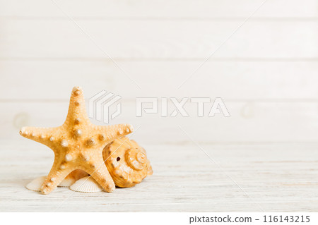 Summer time concept with sea shells or starfish on a table background with copy space for text Summer time concept with sea shells or starfish on a table background with copy space for text 116143215