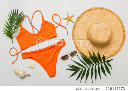Woman swimwear and beach accessories flat lay top view. Top view with bikini outfit on color background. Vacation concept copy space 116143573