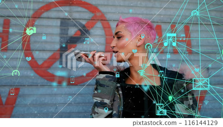 Image of connected icons globes over biracial woman talking on speaker of cellphone 116144129