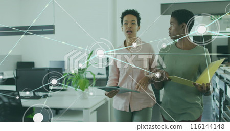 Image of connected dots over diverse female coworkers discussing reports while walking in office Image of connected dots over diverse female coworkers discussing reports while walking in office 116144148